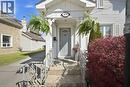 Front entrance featuring a light gray door with an arched window insert, flanked by white decorative columns - 401 West Street, Simcoe, ON  - Outdoor 