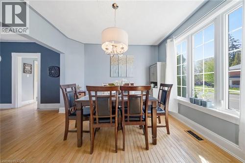 Dining area featuring wood-finish flooring, a contemporary drum pendant light fixture, and a large multi-pane window - 401 West Street, Simcoe, ON - Indoor Photo Showing Dining Room