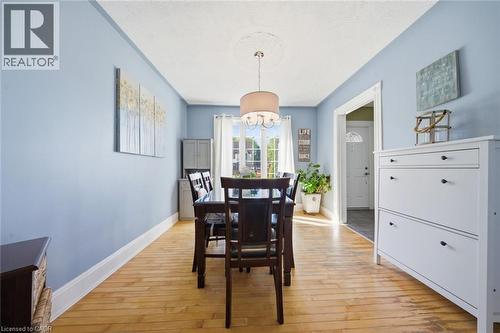 Light wood-finish flooring complements the interior with soft blue walls and white trim - 401 West Street, Simcoe, ON - Indoor Photo Showing Dining Room