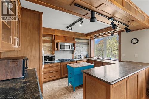 Kitchen featuring wood cabinetry, stone-look countertops, a built-in microwave, and a gas cooktop with a white tile backsplash - 3 San Pedro Drive, Hamilton, ON - Indoor Photo Showing Kitchen