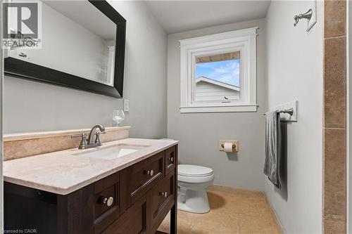 Bathroom featuring a dark wood vanity, light stone countertop, undermount sink, and polished chrome faucet - 3 San Pedro Drive, Hamilton, ON - Indoor Photo Showing Bathroom