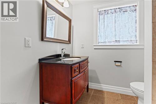 Bathroom vanity featuring a dark wood-finish cabinet with a granite countertop and an undermount sink - 3 San Pedro Drive, Hamilton, ON - Indoor Photo Showing Bathroom