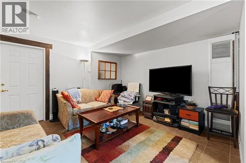 Living space featuring tile flooring, a white paneled door with brass hardware, and a wood-trimmed window - 3 San Pedro Drive, Hamilton, ON - Indoor Photo Showing Living Room