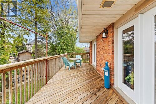 Spacious exterior deck featuring natural wood flooring and railing, brick exterior wall, and white-framed glass doors - 3 San Pedro Drive, Hamilton, ON - Outdoor With Deck Patio Veranda With Exterior