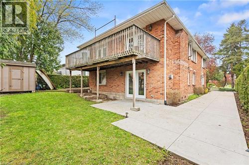 Red brick exterior featuring a second-story wood-railed balcony, a ground-level patio, and double glass doors - 3 San Pedro Drive, Hamilton, ON - Outdoor