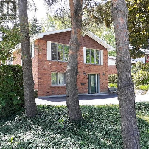 Brick facade residence featuring a dark green entrance door, white window shutters, and a shingled gable accent - 3 San Pedro Drive, Hamilton, ON - Outdoor