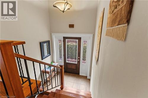 Foyer entryway featuring a wood-panel door with decorative glass sidelights, tiled flooring, and a contemporary ceiling light fixture - 3 San Pedro Drive, Hamilton, ON - Indoor Photo Showing Other Room
