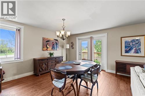 Dining area featuring wood-finish flooring, a contemporary chandelier, and French doors opening to an outdoor deck - 3 San Pedro Drive, Hamilton, ON - Indoor Photo Showing Dining Room