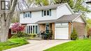 Traditional two-story residence featuring brick and siding facade, a prominent bay window, attached single-car garage, mature landscaping, and a paved driveway leading to stone steps - 19 Chateau Court, Hamilton, ON  - Outdoor 