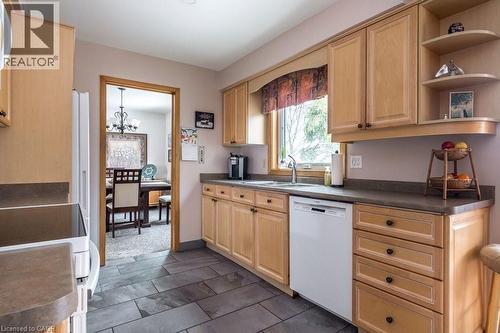 Kitchen featuring wood cabinetry, stone-look countertops, a double-basin sink, and tile flooring - 19 Chateau Court, Hamilton, ON - Indoor Photo Showing Kitchen