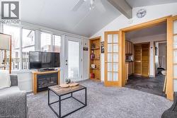 Sunroom with vaulted ceiling, wall of windows, and a built-in electric fireplace - 