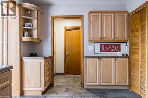 Light wood-finish cabinetry featuring curved open shelving, stone-finish countertops, and under-cabinet lighting - 19 Chateau Court, Hamilton, ON - Indoor Photo Showing Other Room