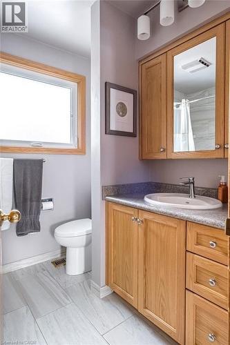 Bathroom with a light wood-finish vanity, integrated sink, and granite-look countertop - 19 Chateau Court, Hamilton, ON - Indoor Photo Showing Bathroom