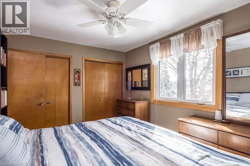 Bedroom featuring a large window, dual sliding closet doors, a ceiling fan with integrated lighting, and a neutral wall color - 19 Chateau Court, Hamilton, ON - Indoor Photo Showing Bedroom