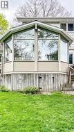 Exterior sunroom addition featuring large, clear windows and neutral-toned paneling - 
