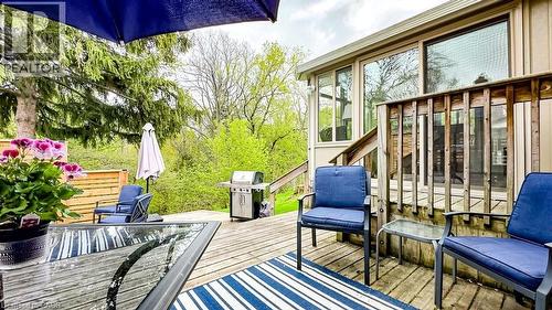 Multi-level wood deck featuring a built-in railing, direct access to the interior via sliding glass doors, and a natural tree-lined backdrop - 19 Chateau Court, Hamilton, ON - Outdoor With Deck Patio Veranda With Exterior