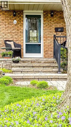 Brick facade with a contrasting dark green entry door and decorative screen door - 19 Chateau Court, Hamilton, ON - Outdoor With Deck Patio Veranda
