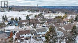 Aerial perspective of a residential street with homes featuring pitched roofs and varied exterior finishes - 