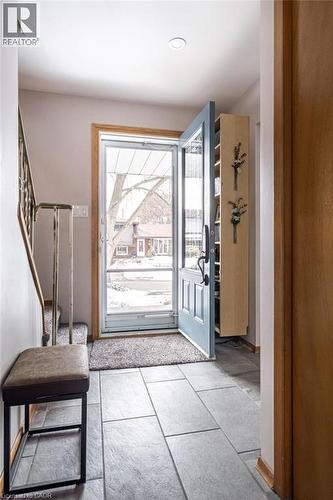 Entryway featuring large format rectangular floor tiles, a light blue main door with glass panels, a recessed ceiling light, and a built-in light wood storage unit - 19 Chateau Court, Hamilton, ON - Indoor Photo Showing Other Room