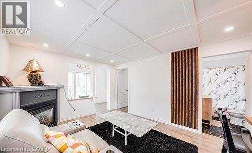 Spacious living area featuring a coffered ceiling with recessed lighting, a fireplace with a mantel, and wood-finish flooring - 43 Adair Avenue S, Hamilton, ON - Indoor With Fireplace