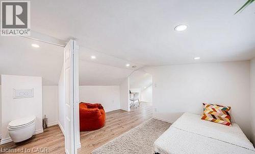 Attic space featuring wood-finish flooring, recessed lighting, and a partial wall with a built-in toilet - 43 Adair Avenue S, Hamilton, ON - Indoor Photo Showing Other Room