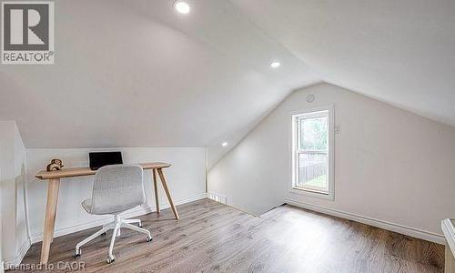Attic space featuring sloped ceilings, recessed lighting, wood-finish flooring, a single window, and white trim - 43 Adair Avenue S, Hamilton, ON - Indoor Photo Showing Other Room