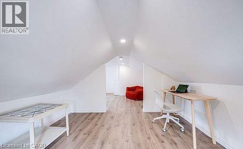 Attic space featuring wood-finish flooring, white sloped ceilings, recessed lighting, and white baseboards - 43 Adair Avenue S, Hamilton, ON - Indoor Photo Showing Other Room