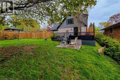 Expansive backyard featuring a wood fence, mature tree, and a multi-level deck with black railings - 49 Ashwood Drive, Cambridge, ON - Outdoor With Deck Patio Veranda
