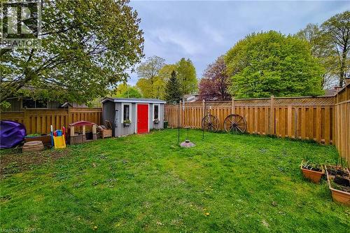 Spacious backyard featuring a manicured lawn, a privacy fence with lattice detailing, and mature trees providing natural shading - 49 Ashwood Drive, Cambridge, ON - Outdoor With Backyard