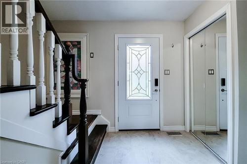 Entryway featuring a white door with decorative glass, light-toned tile flooring, and a mirrored closet - 49 Ashwood Drive, Cambridge, ON - Indoor Photo Showing Other Room