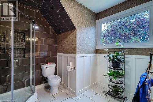 Bathroom with a glass-enclosed shower, brown subway tile, white board and batten paneling, and a large window - 49 Ashwood Drive, Cambridge, ON - Indoor Photo Showing Bathroom