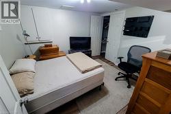 Room featuring light wood-finish flooring, white walls, and a built-in closet with bi-fold doors - 