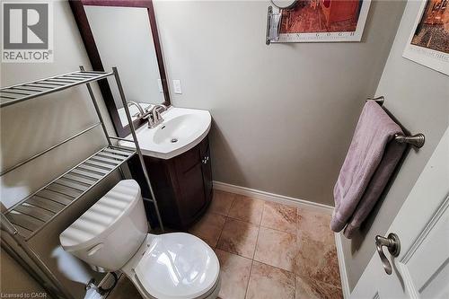Bathroom featuring a curved vanity with a built-in white sink, brushed nickel faucet, and a coordinating framed mirror - 49 Ashwood Drive, Cambridge, ON - Indoor Photo Showing Bathroom