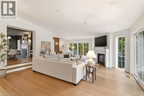 Spacious living area featuring wood-finish flooring, recessed lighting, and a white mantel fireplace - 3081 Balmoral Avenue, Burlington, ON - Indoor Photo Showing Living Room With Fireplace