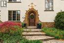 Arched stone entry with a solid wood door, complemented by a stone staircase - 3081 Balmoral Avenue, Burlington, ON  - Outdoor 