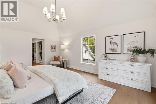 Vaulted ceiling bedroom with wood-finish flooring, a contemporary chandelier, and a walk-in closet - 3081 Balmoral Avenue, Burlington, ON - Indoor Photo Showing Bedroom