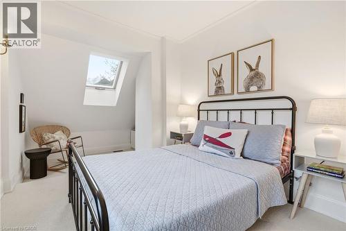 Bedroom featuring a sloped ceiling, an operable skylight, white wall finishes, and light-colored carpeting - 3081 Balmoral Avenue, Burlington, ON - Indoor Photo Showing Bedroom