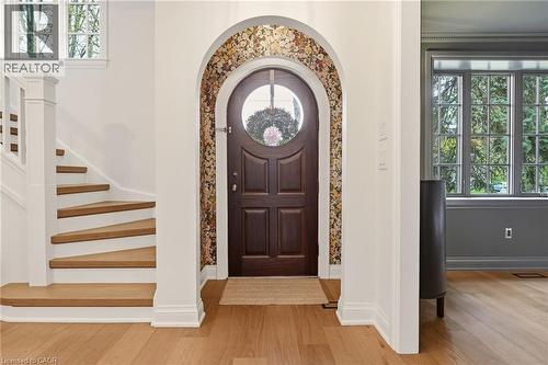 Arched entryway with a dark wood door featuring a circular glass insert - 3081 Balmoral Avenue, Burlington, ON - Indoor Photo Showing Other Room