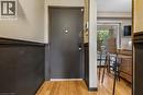Entryway featuring wood-finish flooring, a two-tone wall treatment with wainscoting, and a dark-toned entry door with smart lock hardware - 21 Lionshead Lookout, Brampton, ON  - Indoor Photo Showing Other Room 