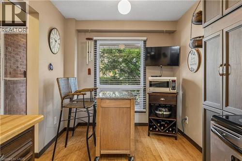 Kitchen space featuring wood-finish flooring, a window with horizontal blinds, and a built-in oven range - 21 Lionshead Lookout, Brampton, ON - Indoor