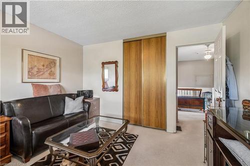 Carpeted room featuring a closet with wood-finish sliding doors and a doorway - 21 Lionshead Lookout, Brampton, ON - Indoor Photo Showing Living Room