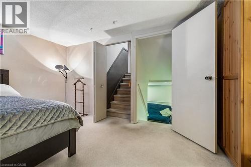 Carpeted room with a partial bed frame, two white doors, and a wood-finish wardrobe - 21 Lionshead Lookout, Brampton, ON - Indoor Photo Showing Bedroom
