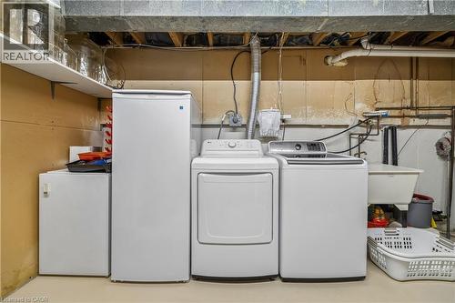 Laundry area featuring a side-by-side washer and dryer, utility sink, and overhead shelving - 21 Lionshead Lookout, Brampton, ON - Indoor Photo Showing Laundry Room