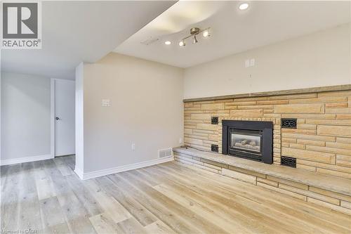 Stone-clad fireplace with black insert - 38 Dunkirk Drive Unit# B, Hamilton, ON - Indoor Photo Showing Living Room With Fireplace