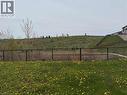 Expansive green space featuring a chain-link fence, a sloped grassy hill, and distant residential structures - 63 Ridge Road Unit# Upper, Cambridge, ON  - Outdoor 