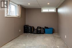 Room featuring concrete flooring, neutral wall paint, and a drop ceiling with recessed lighting - 