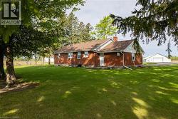 Brick exterior residence with a brown shingle roof, white trim, and a prominent chimney - 