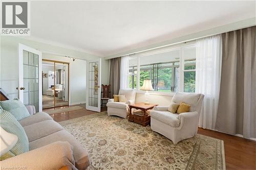 Living area featuring a large picture window, hardwood flooring, and a decorative area rug - 10 Huisman Lane, Hamilton, ON 