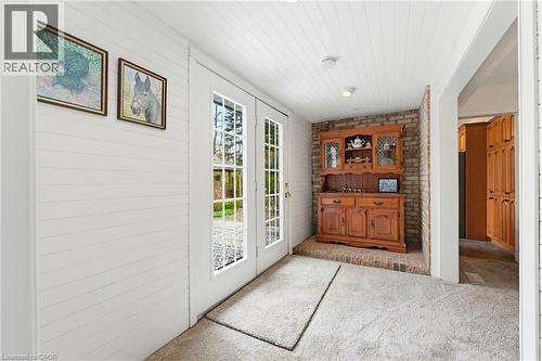 Double French doors with muntin bars, shiplap walls, brick accent wall, and recessed lighting - 10 Huisman Lane, Hamilton, ON 