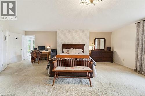 Spacious room featuring neutral carpet flooring, light-toned wall paint, and a decorative ceiling light fixture - 10 Huisman Lane, Hamilton, ON 